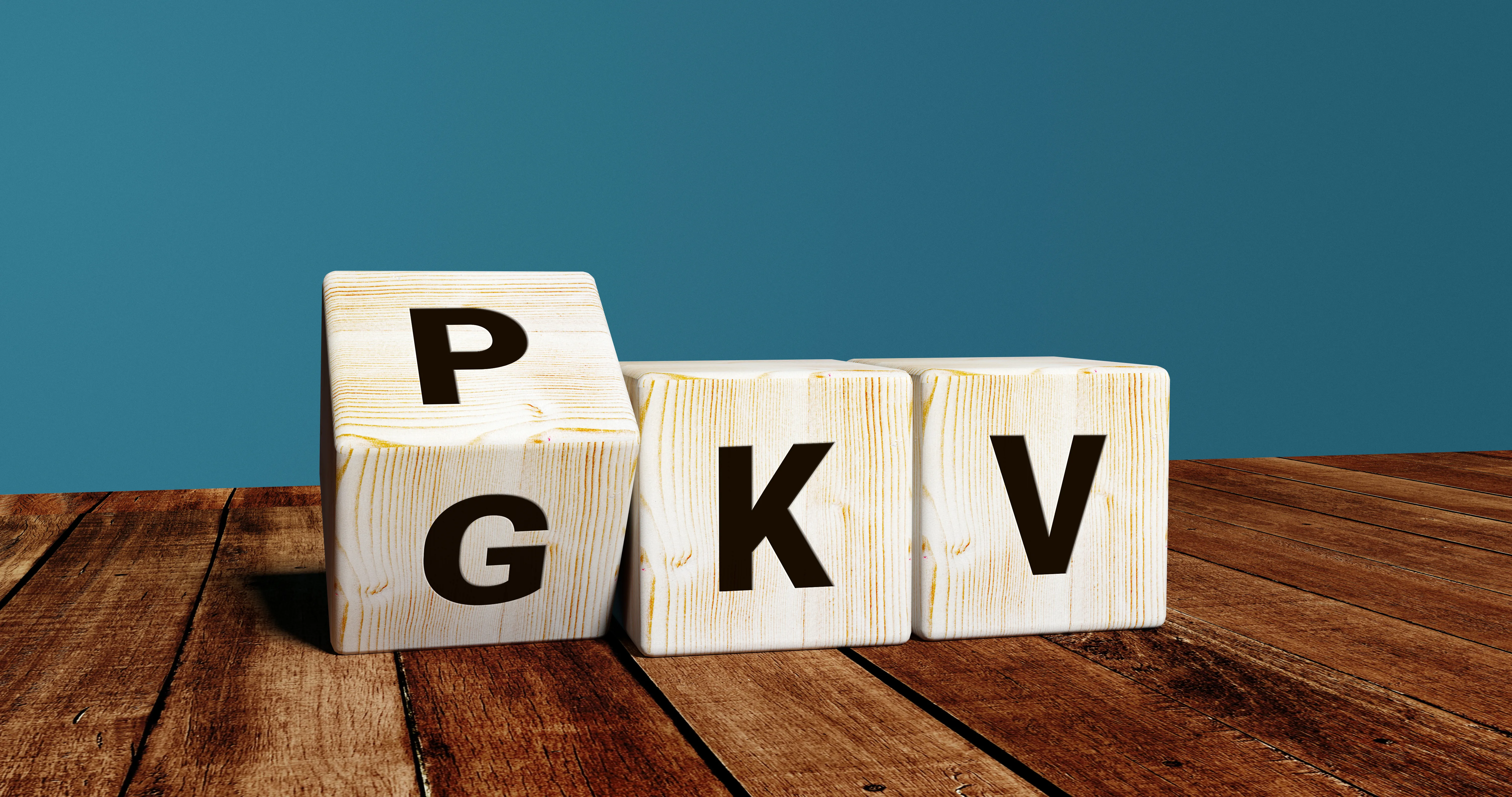 Drei Würfel mit Buchstaben. Der eine Würfel steht auf der Kippe, so kann man auf der einen Würfelseite ein P und auf der anderen ein G erkennen. Dahinter reihen sich die Würfel mit K und V auf. So kann PKV und GKV gelesen werden.